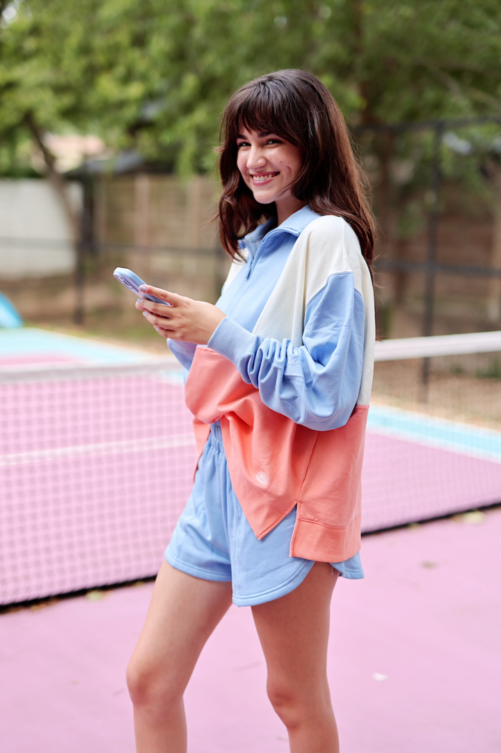 Casual women’s color-blocked sweatshirt in blue and coral, featuring long sleeves and a relaxed fit.