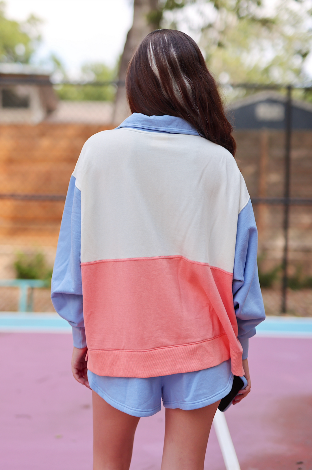Women's color-blocked sweatshirt in blue, white, and coral, featuring a relaxed fit and soft material.