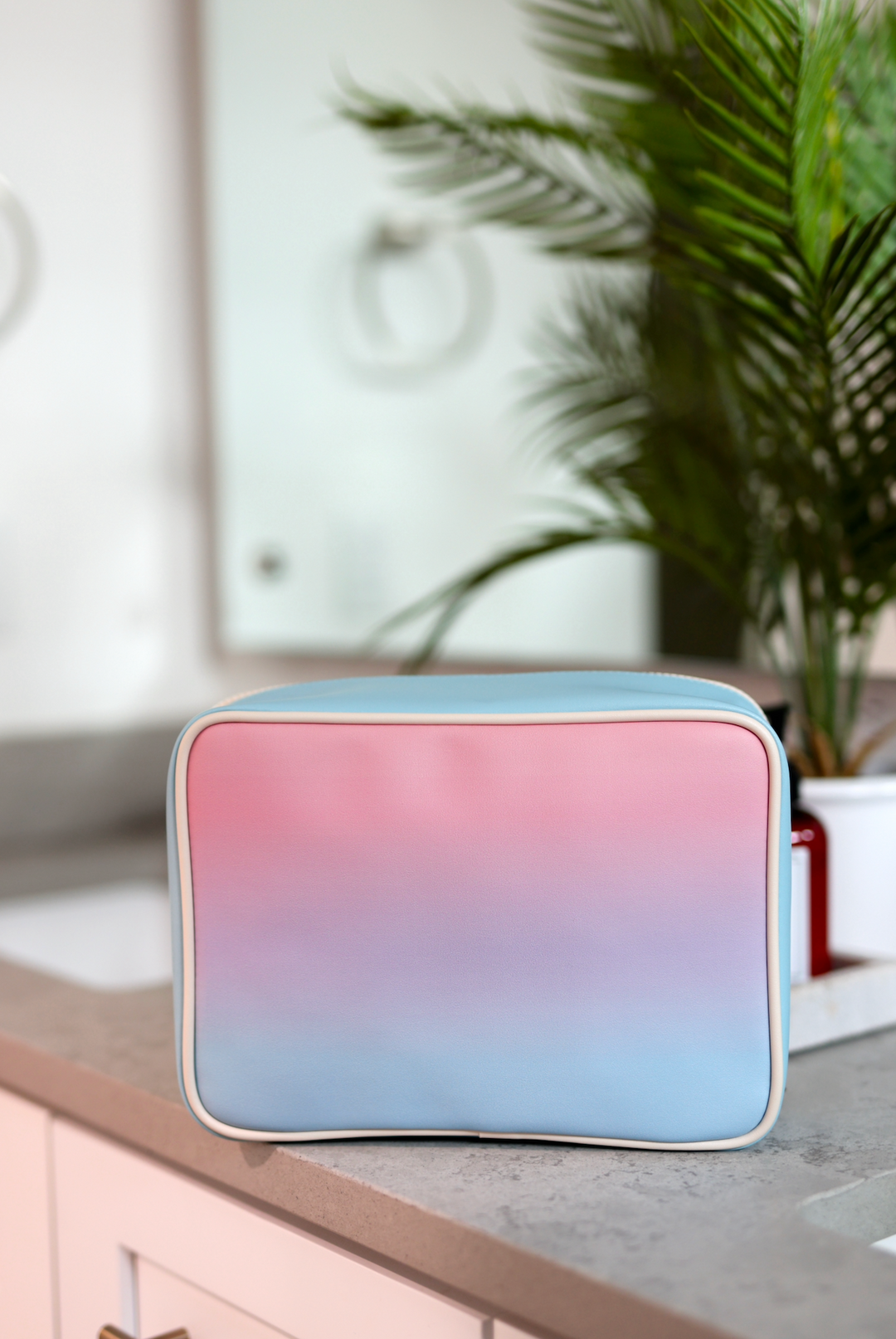 Pink and blue gradient cosmetic bag, stylish and durable, perfect for travel and organization.