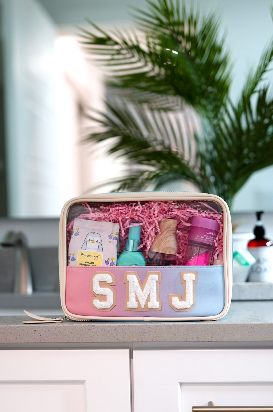 Personalized cosmetic bag in pastel colors with skincare products, perfect for travel or daily use.