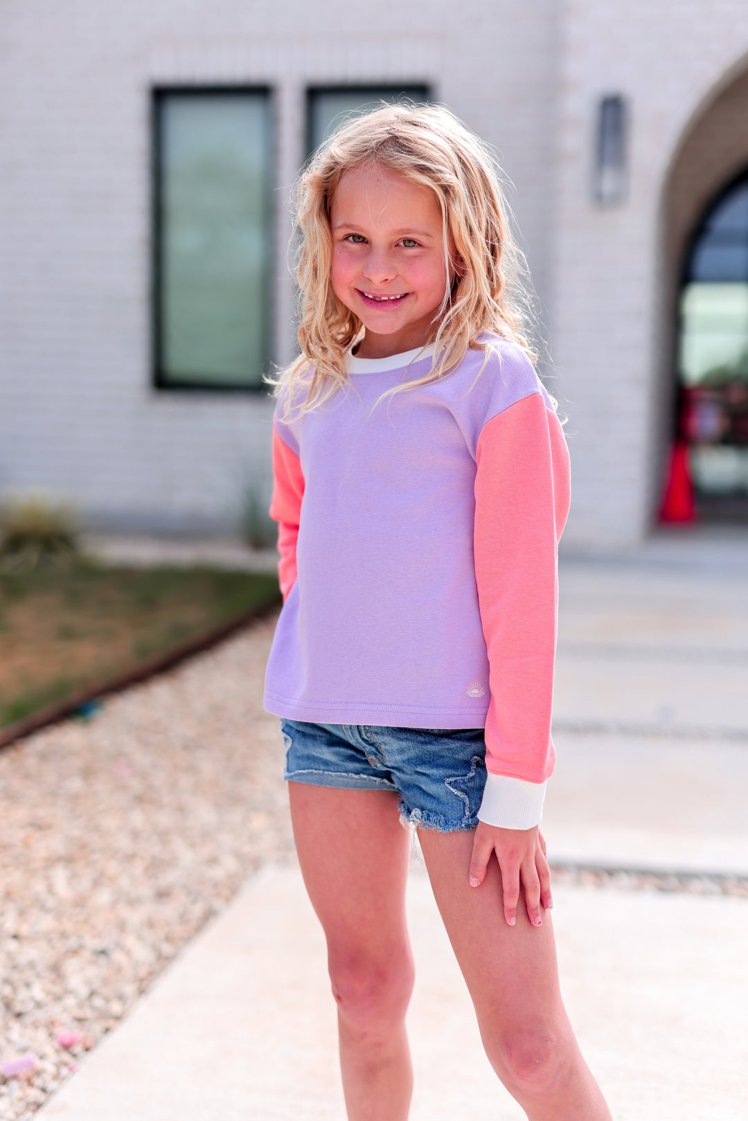 Girls' pastel purple and coral long-sleeve sweatshirt, soft cotton material, casual summer style.