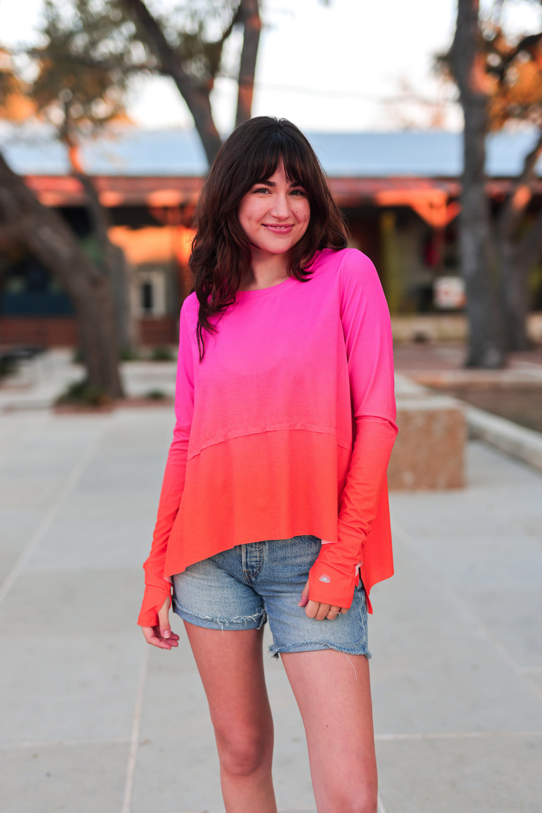 Women's long-sleeve ombre top in bright pink and orange, made from lightweight fabric.