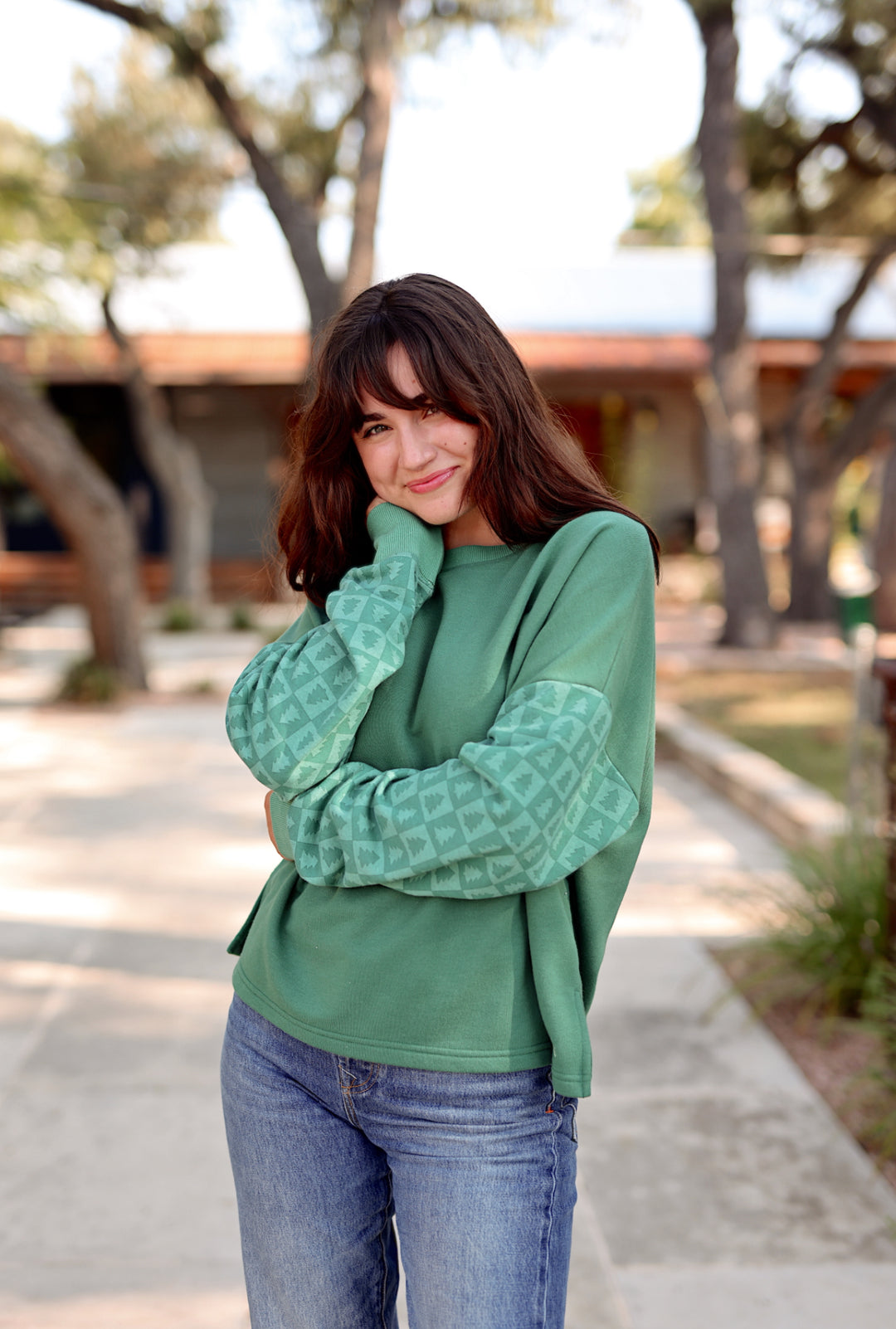Cozy green sweatshirt with patterned sleeves, perfect for casual wear and stylish layering.