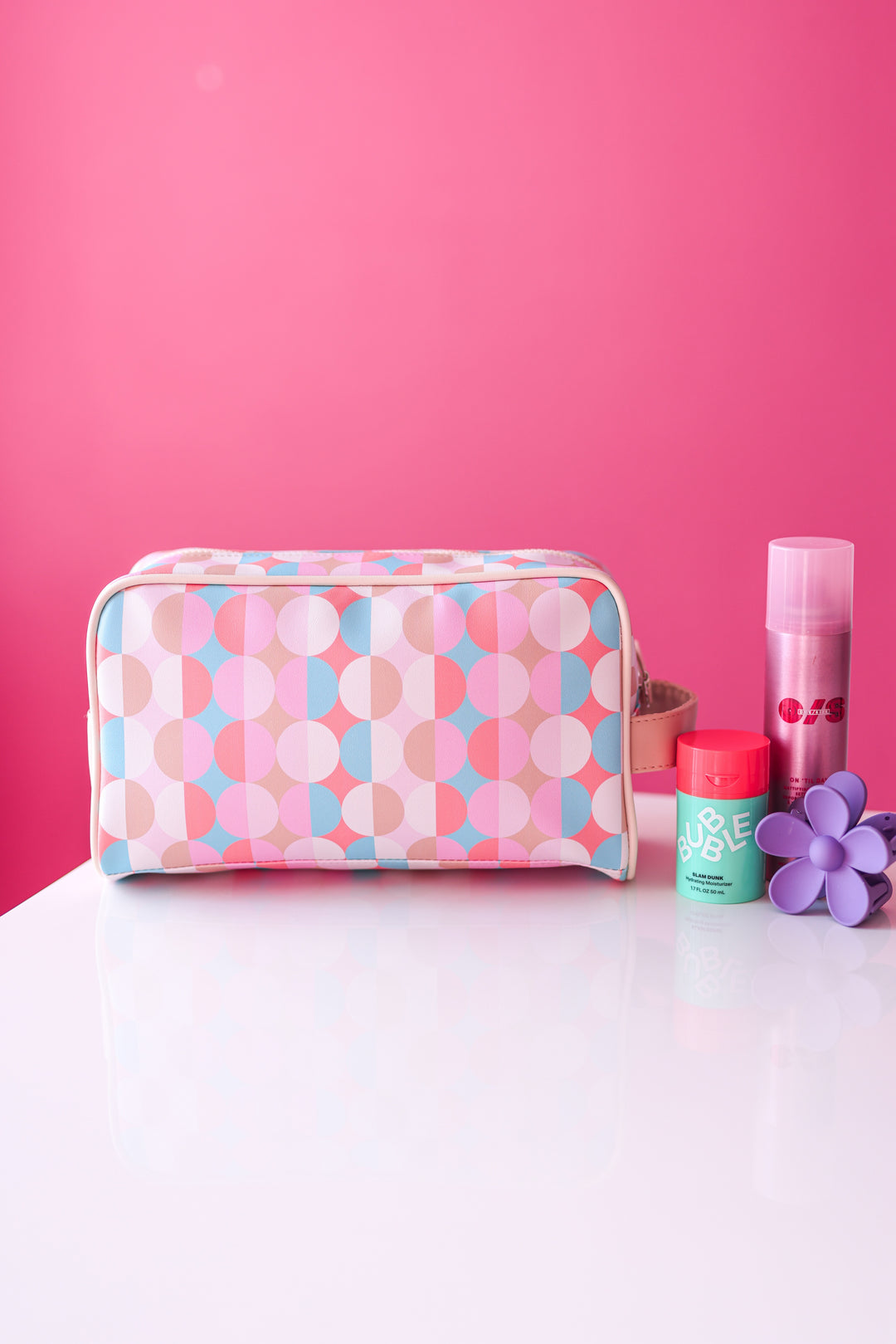 Cosmetic bag with geometric pattern on a pink background