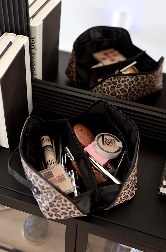 Leopard print makeup bag in black, featuring organized compartments for cosmetics and beauty essentials.
