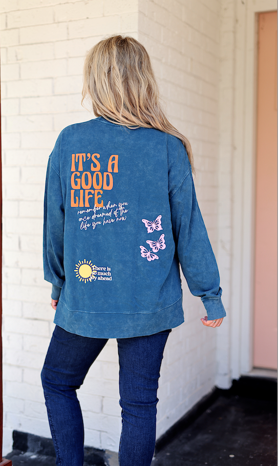 Blue oversized sweatshirt with butterfly graphics and inspirational text on the back.