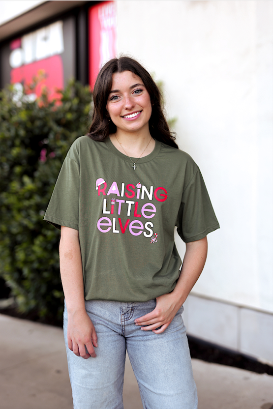 Olive green t-shirt with 'Raising Little Elves' graphic design, made from soft cotton for comfort.