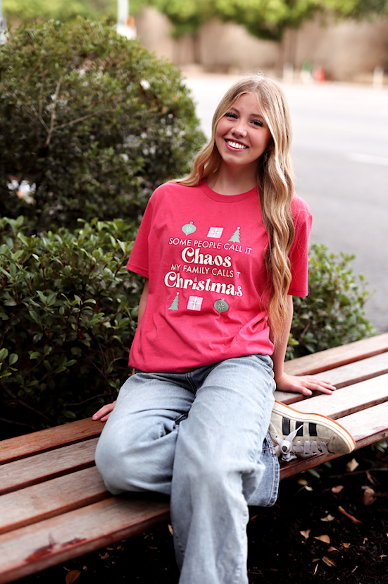 Red graphic t-shirt with Christmas quote, casual style, perfect for festive gatherings.