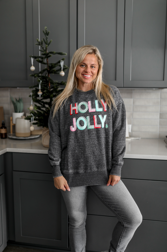 Women's gray sweatshirt featuring 'HOLLY JOLLY' graphic, perfect for festive winter style.