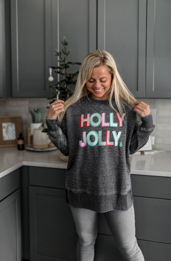 Gray sweatshirt with 'HOLLY JOLLY' print, cozy and festive, perfect for holiday season style.