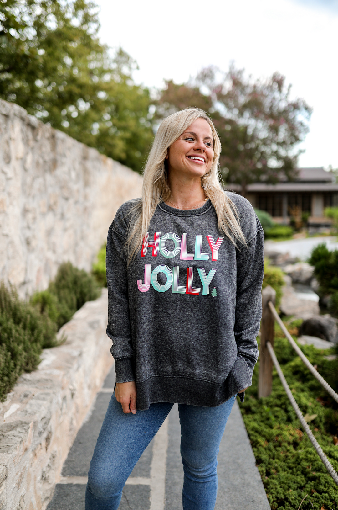 Gray sweatshirt featuring colorful 'HOLLY JOLLY' text, perfect for cozy holiday wear.