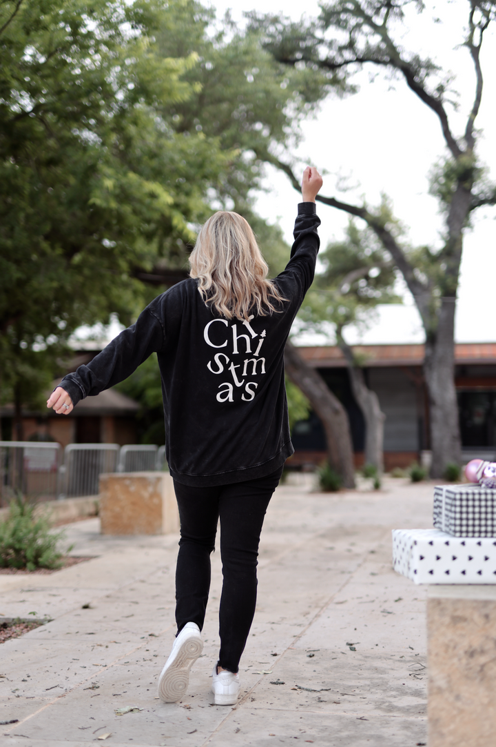 Black Christmas sweatshirt with bold white lettering, perfect for holiday casual wear.