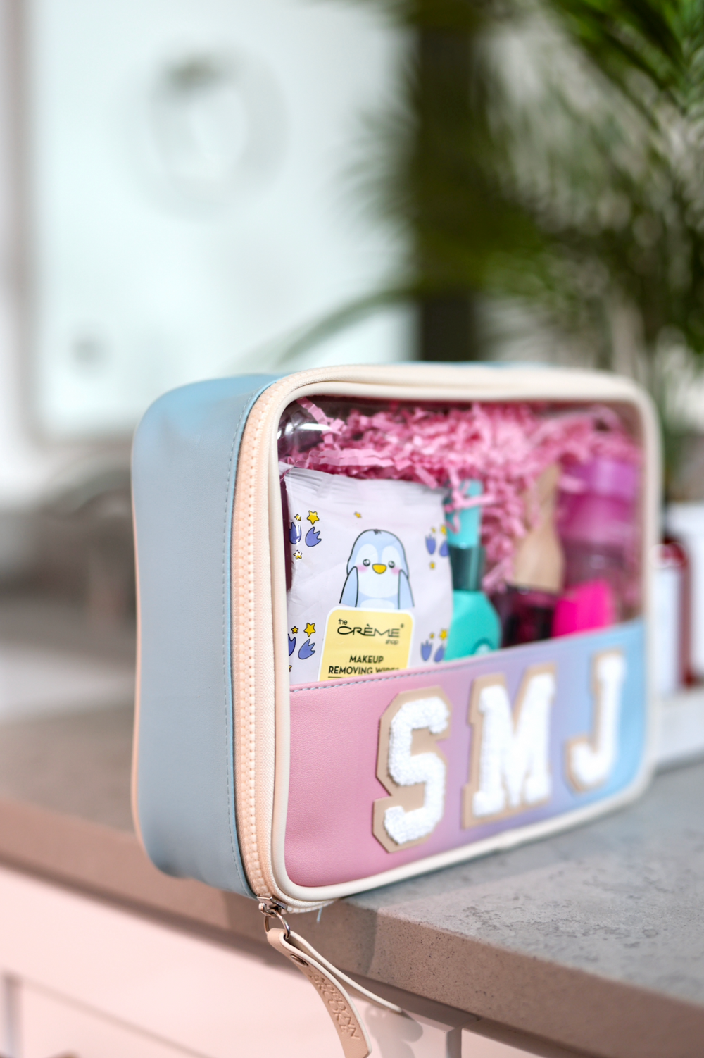 Personalized makeup bag in blue and pink with clear window, ideal for organizing beauty products.