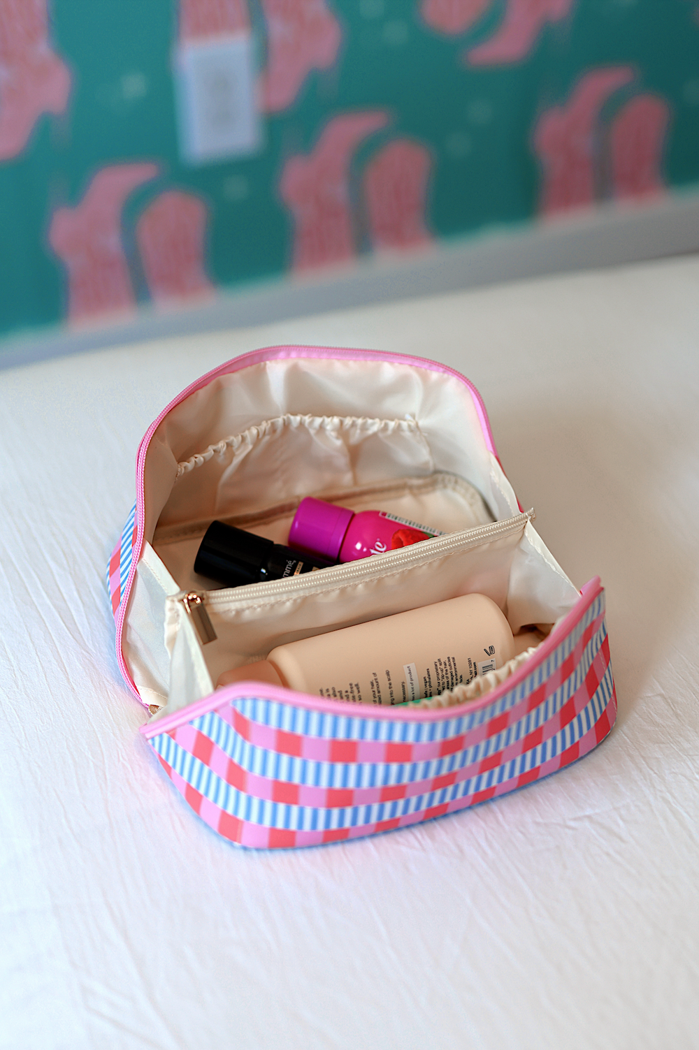 Colorful striped makeup bag with pink and blue accents, ideal for organizing toiletries and cosmetics.