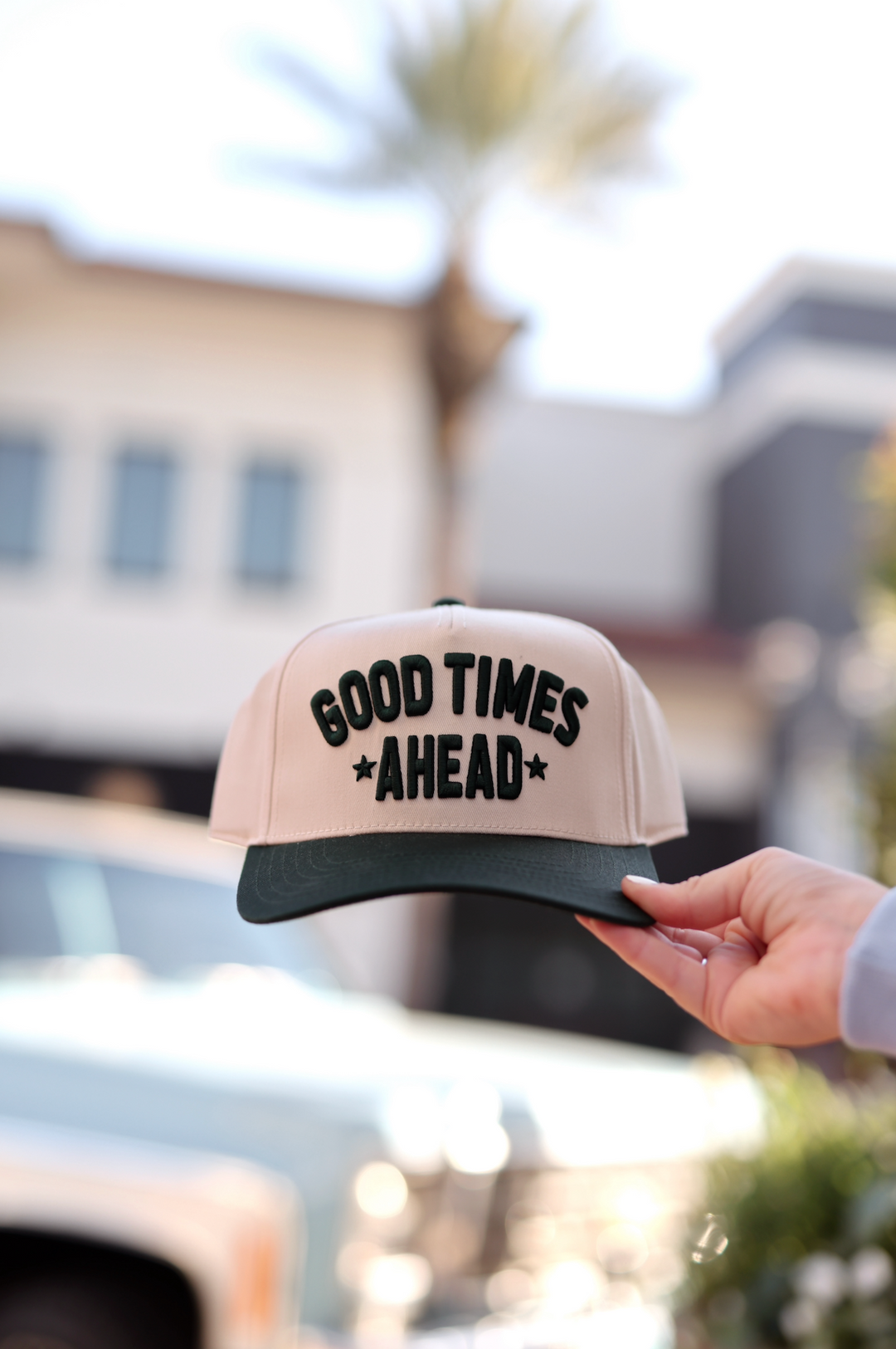 Beige and green snapback cap with 'Good Times Ahead' embroidered design, perfect for casual wear.