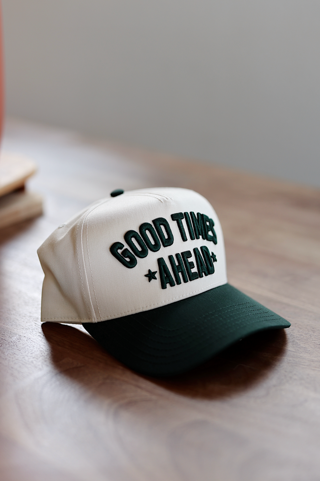 Beige baseball cap with green 'GOOD TIMES AHEAD' embroidery, perfect for casual outings.