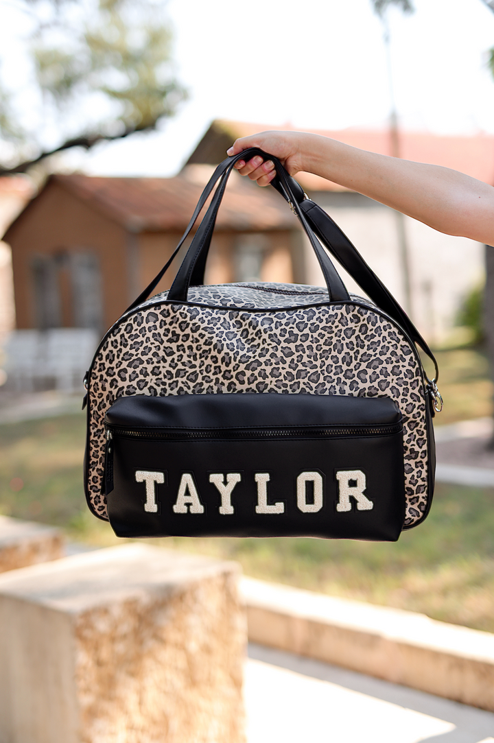 Spacious leopard print weekender bag with black accents and personalized 'TAYLOR' lettering.