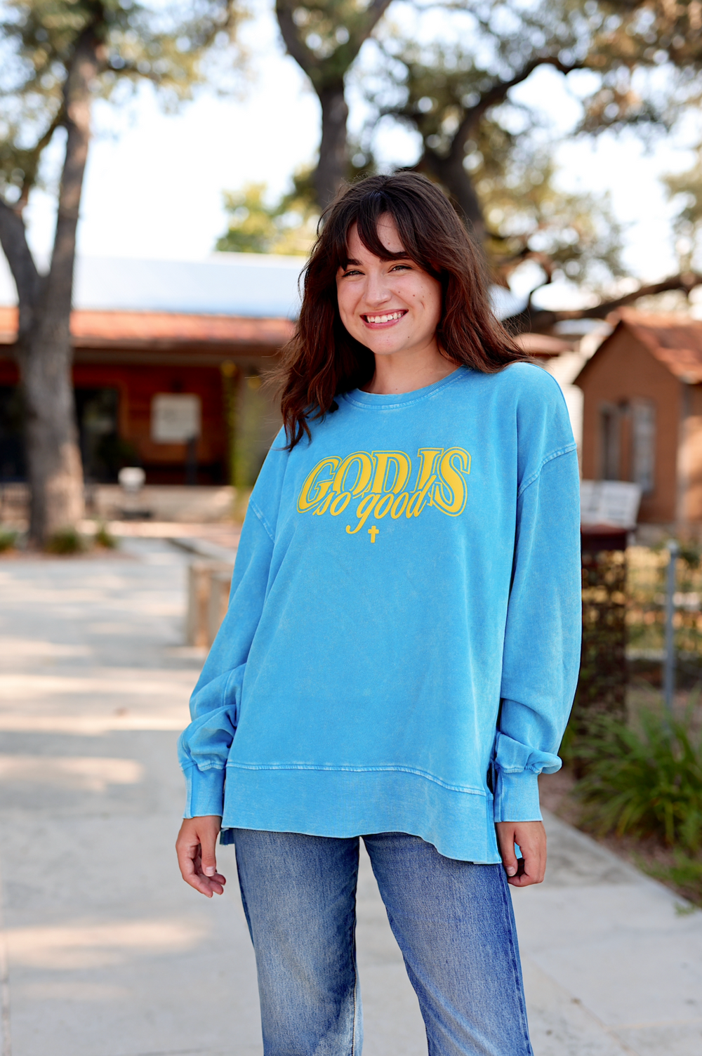 Blue long-sleeve sweatshirt with 'GOD IS so good' print, soft cotton material, casual fit for women.