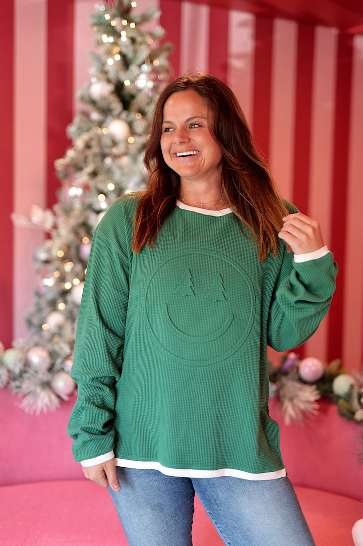 Green waffle-knit sweatshirt with smiley face design, casual and comfortable, perfect for cozy outfits.
