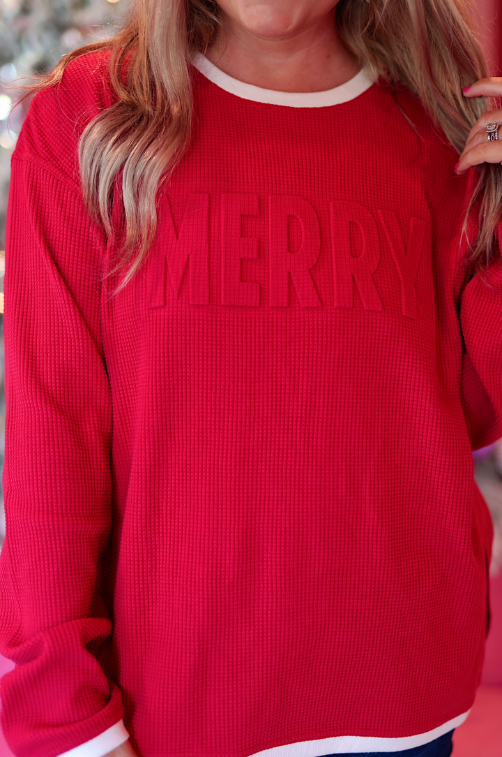 Cozy red 'MERRY' sweatshirt in waffle knit fabric with white trim, perfect for holiday festivities.