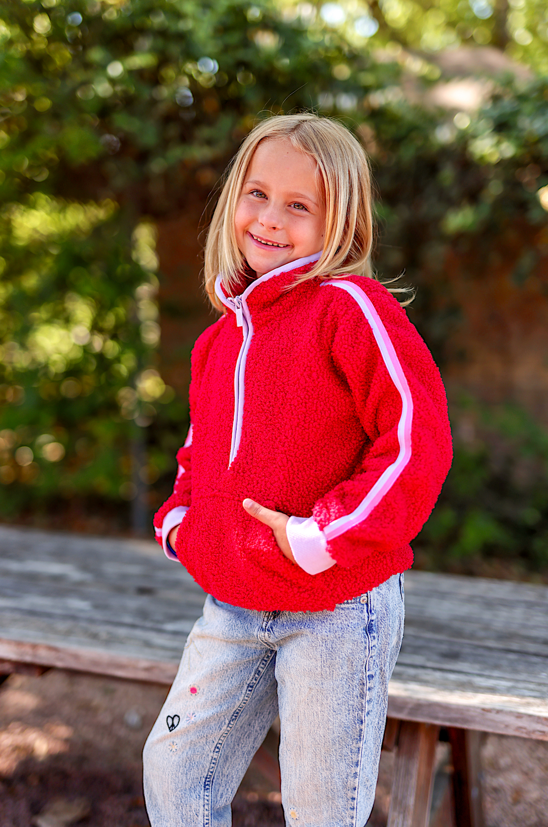 Cozy red fleece pullover for kids with white stripes, perfect for outdoor play and warmth.