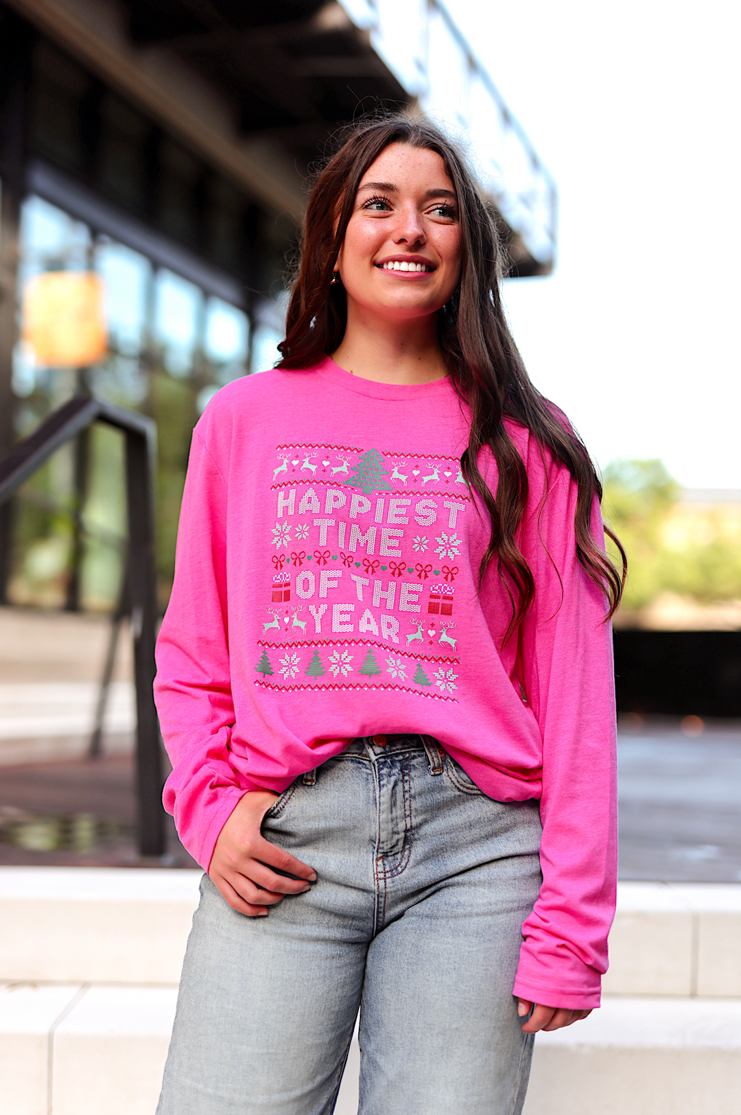 Pink long sleeve shirt featuring 'Happiest Time of the Year' holiday graphic, perfect for festive celebrations.