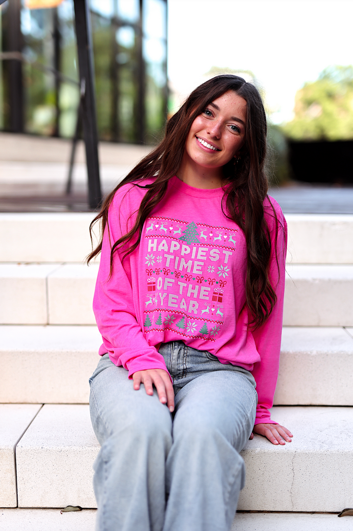 Bright pink long-sleeve Christmas graphic tee with 'Happiest Time of the Year' print