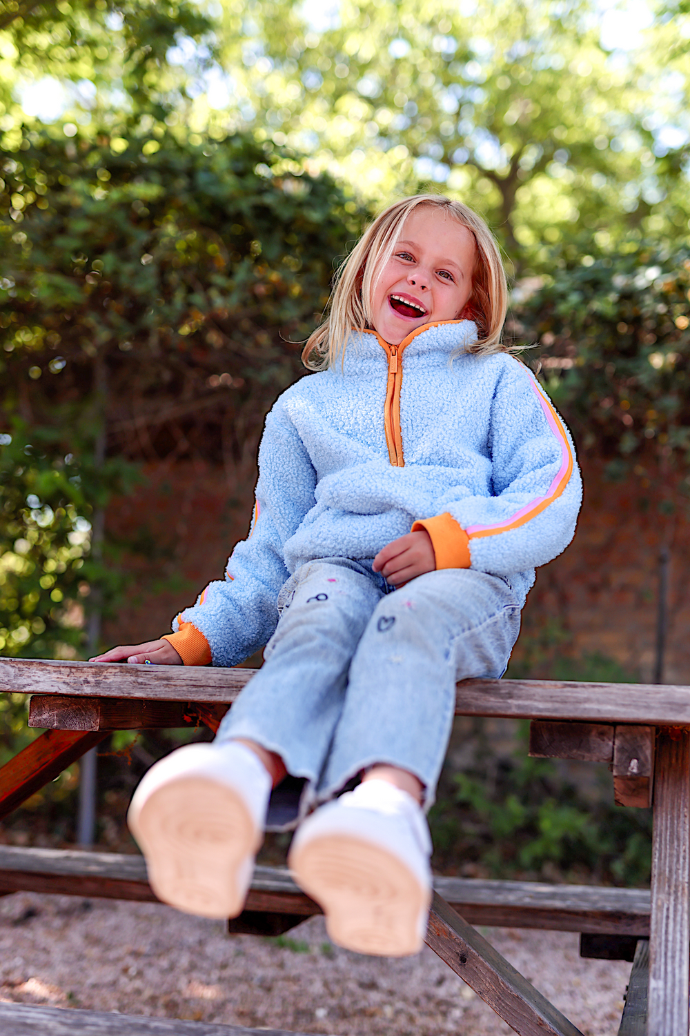 Cozy blue fleece jacket for kids with orange accents, perfect for cool weather and outdoor fun.
