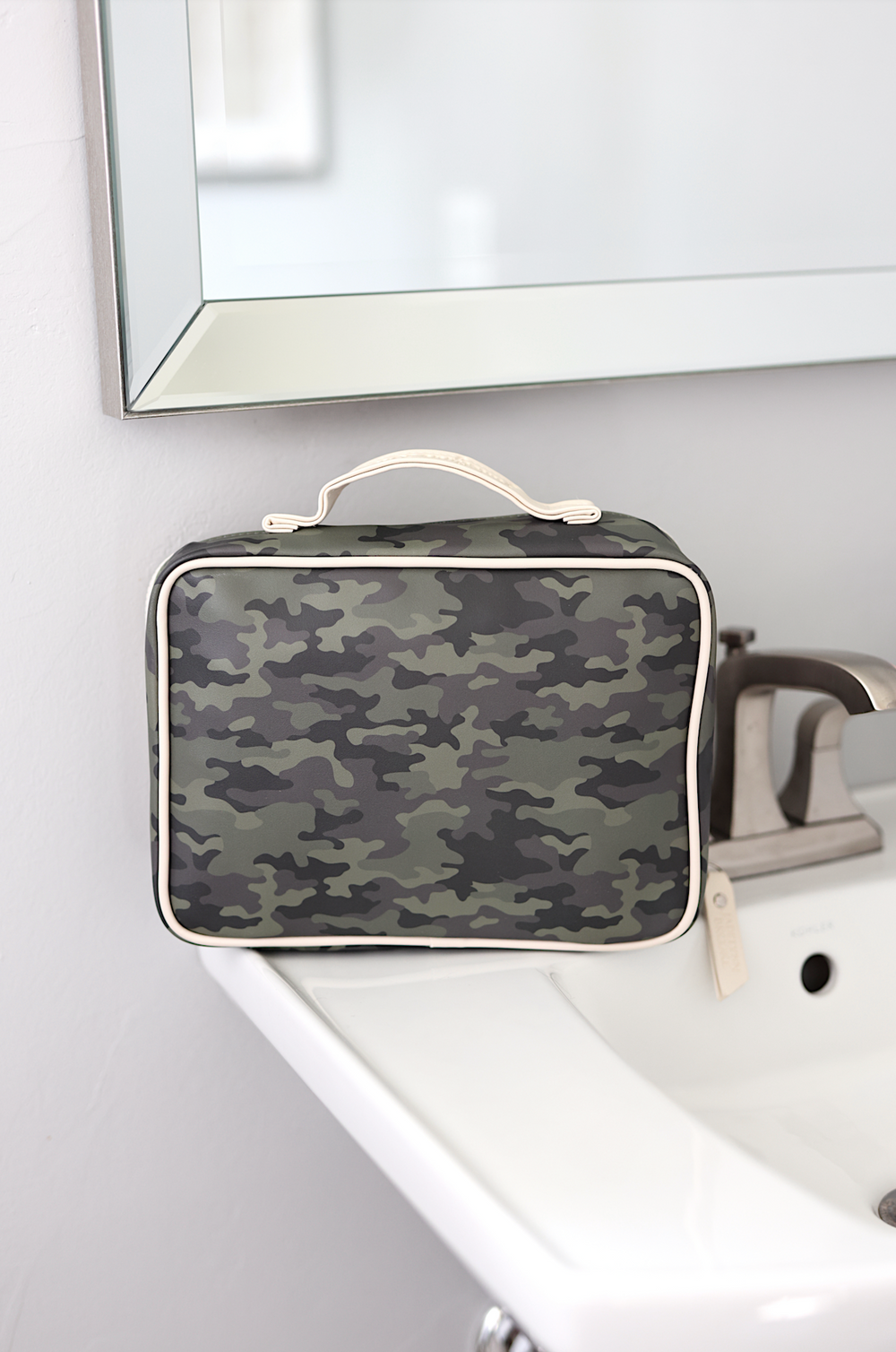 Camouflage travel toiletry bag with cream trim, ideal for organizing personal items.