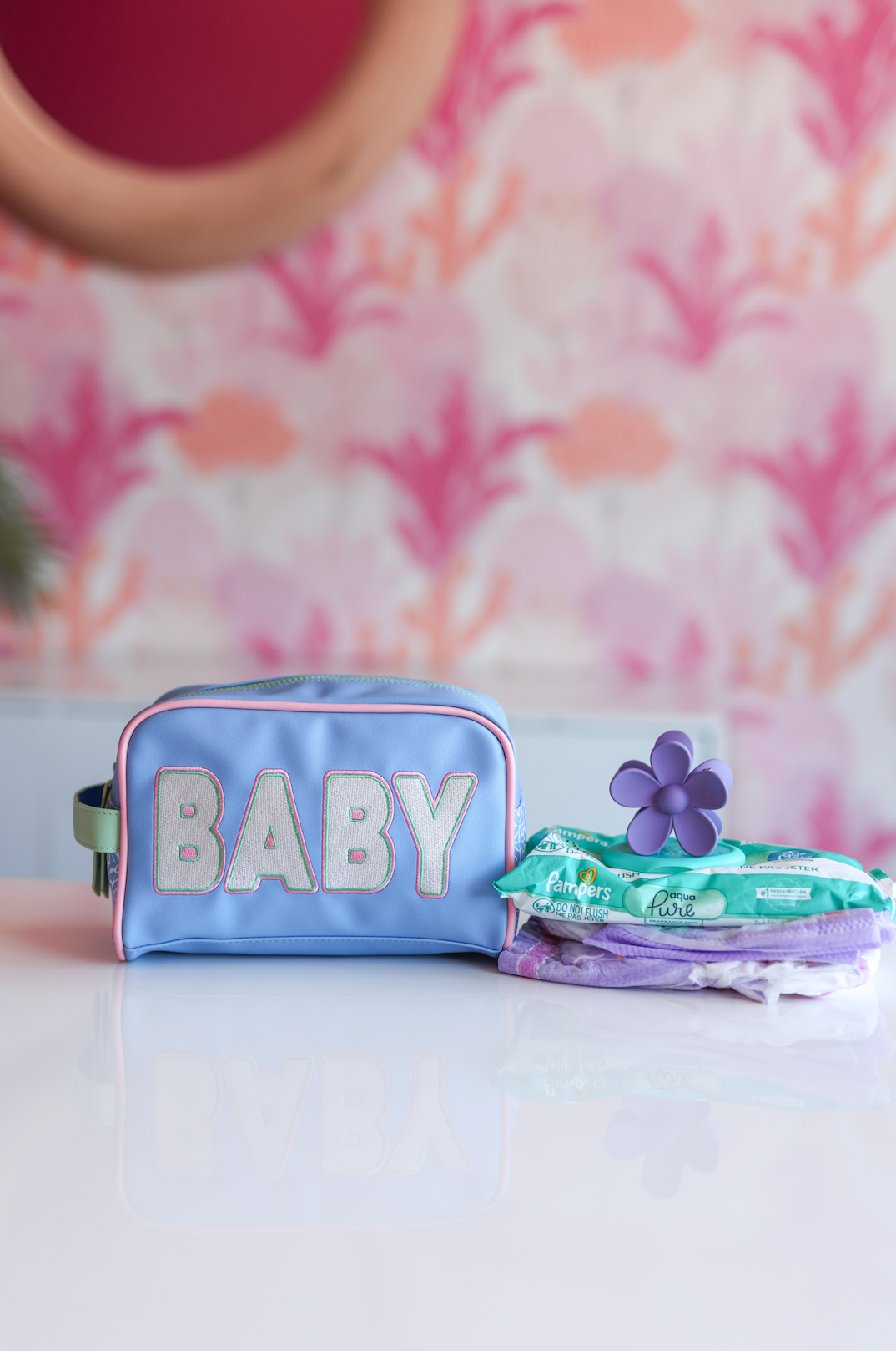 Light blue baby organizer bag with silver lettering, includes wipes and colorful accessories.