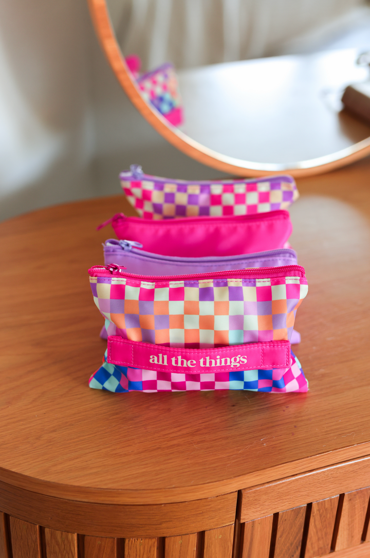 Colorful checkered zipper pouches in pink and purple, perfect for organizing essentials.