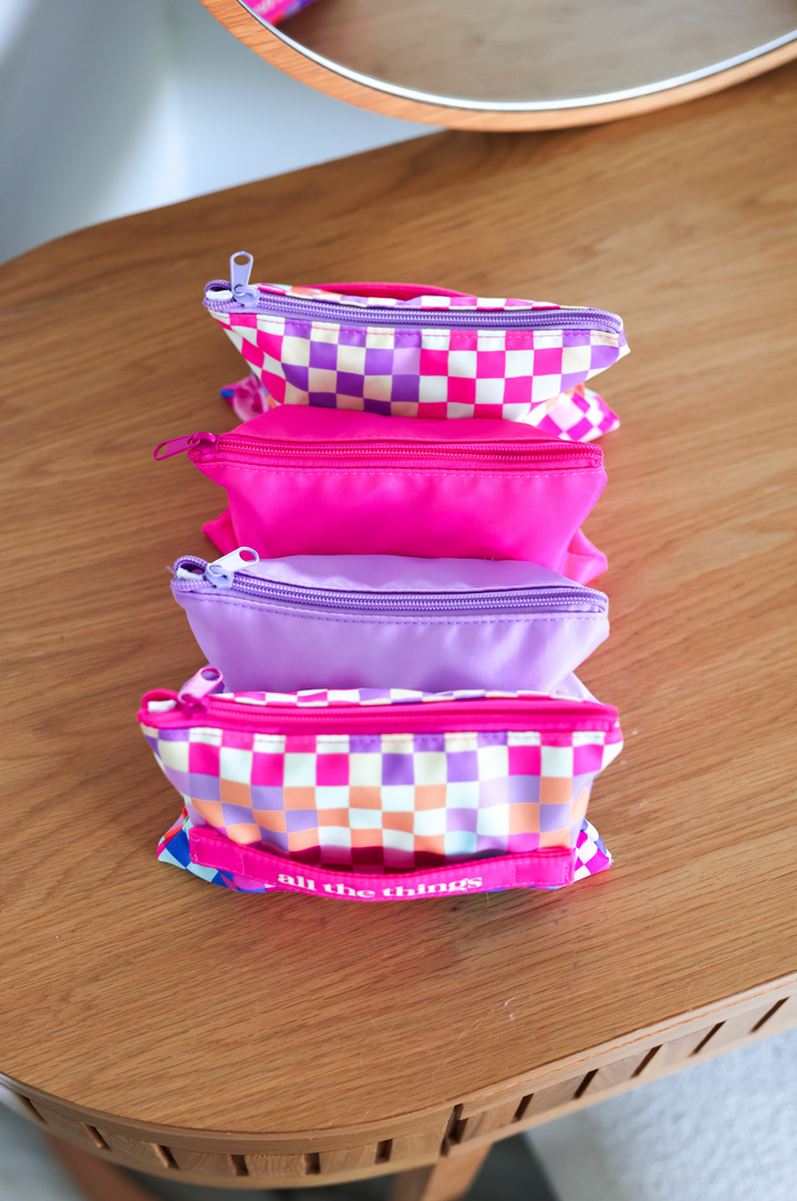 Set of colorful zippered pouches in pink and purple, perfect for organizing essentials.