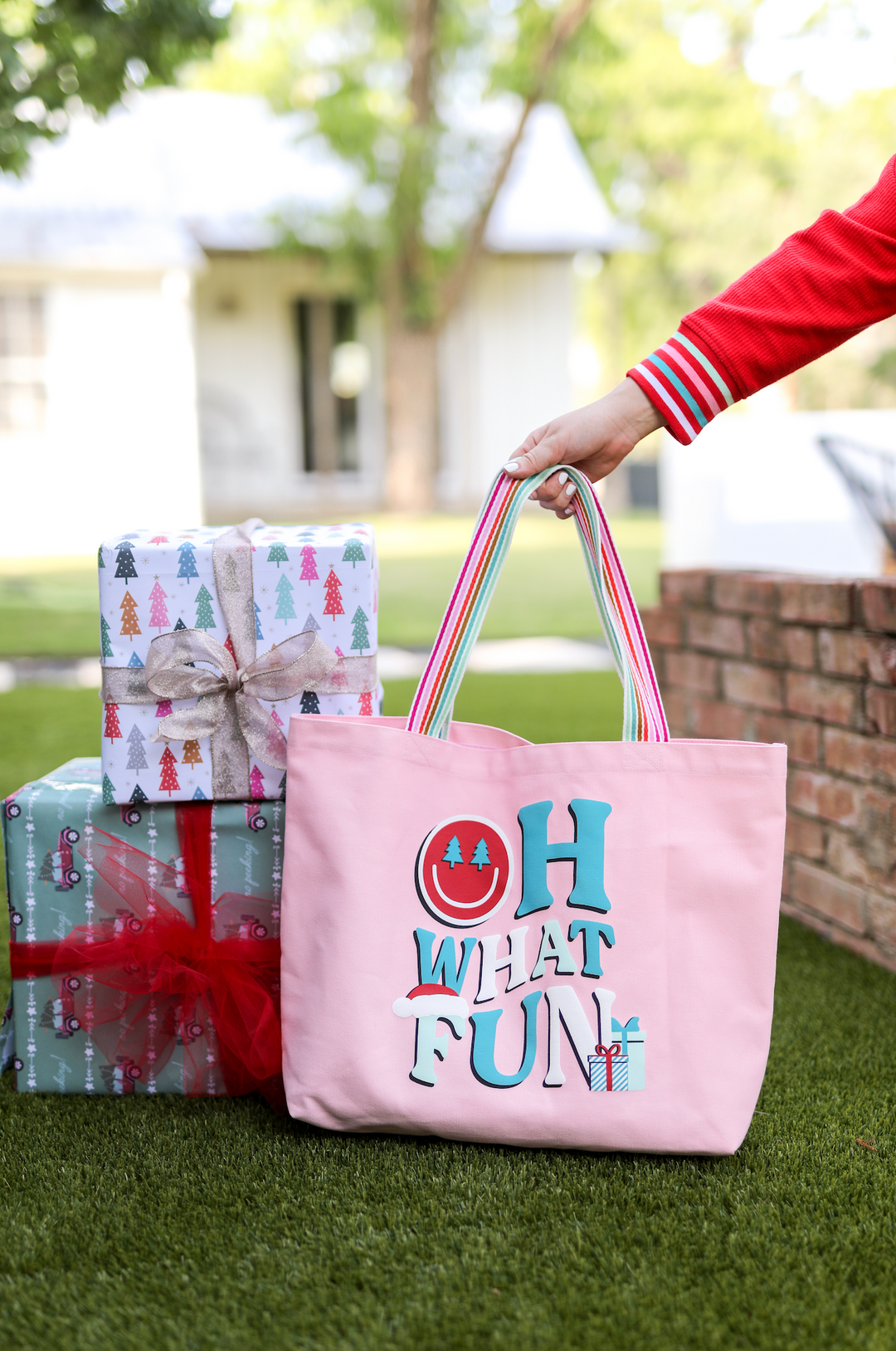 Pink tote bag with colorful 'OH WHAT FUN' print, perfect for holiday gifting and festivities.