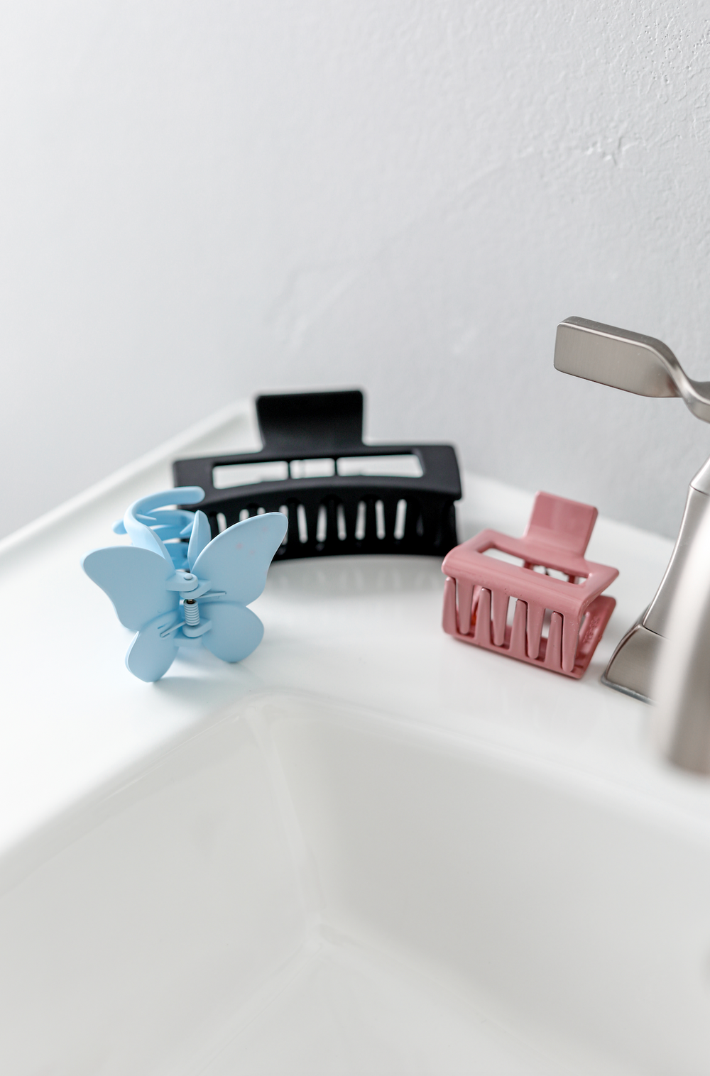 Colorful hair clips set: blue butterfly, black and pink claw clips for stylish hair management.